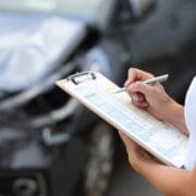 Insurance agent conducts inspection of the damaged car by filling out documents