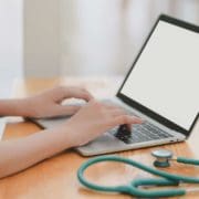 Doctor sitting at a desk on telehealth call with stethoscope nearby